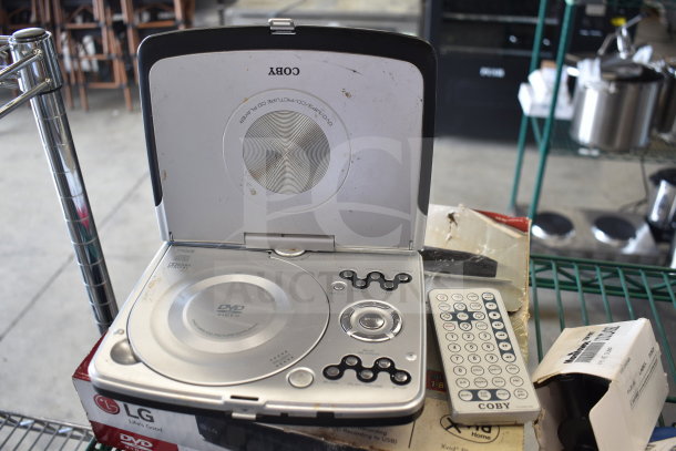 Two DVD players, LG and Coby, with remote. Signs of wear present. Includes original packaging and manuals.