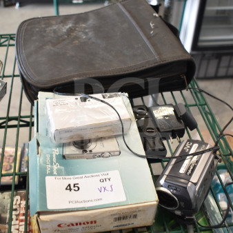 5-item lot includes Canon PowerShot digital camera and JVC camcorder. Items show signs of wear. Boxed camera has label: "For More Great Auctions Visit."