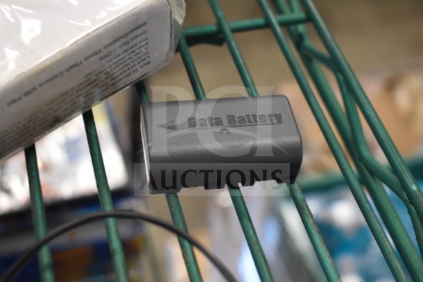 Battery on a metal rack, labeled "Data Battery." Partial view of a white package on the left.