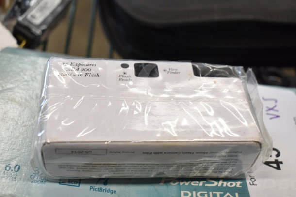 Plastic-wrapped Canon digital camera box. Label mentions 35mm flash camera, 24 exposures, ISO 200, built-in flash.