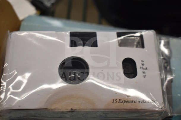 Various items including disposable camera in packaging, labeled "15 Exposures, ASA 400," part of auction lot with Canon camera, JVC recorder.