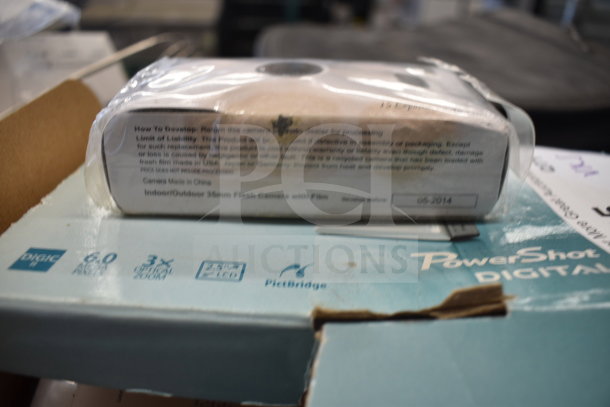 Package with Canon PowerShot box, visible labels on a 35mm flash camera, marked as made in China, dated 05-2014.