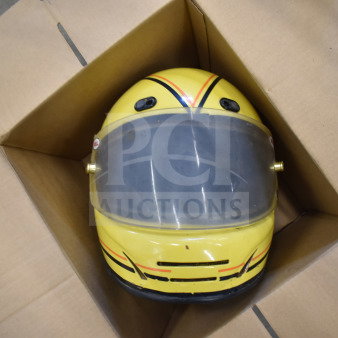 Yellow Simpson VN 6-7/8 helmet with clear visor, placed in a cardboard box. Features racing stripes and vent detail.