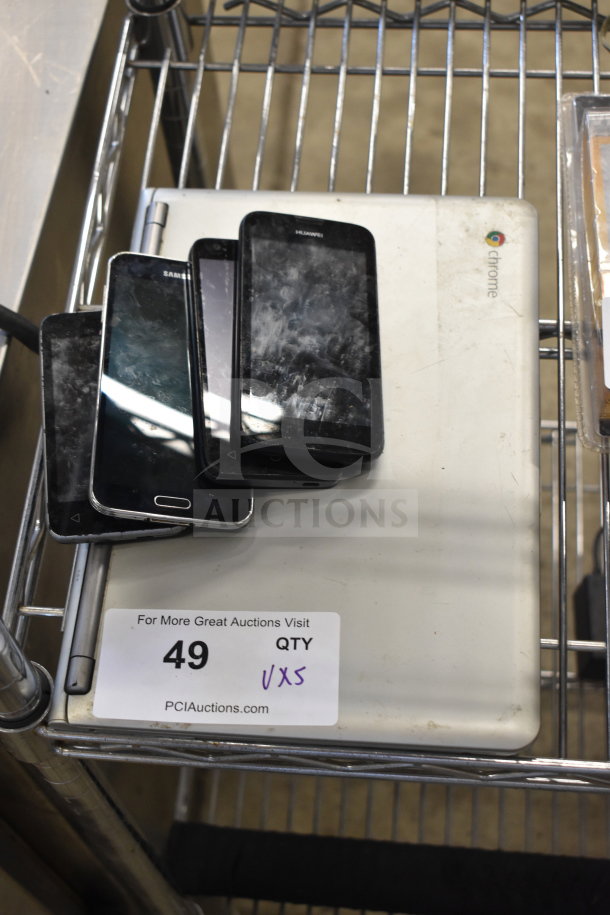 Samsung laptop with 4 used smartphones, visible wear. Auction tag with quantity 5x indicates lot details.