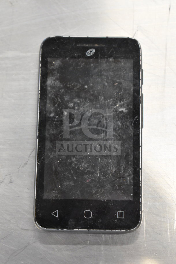 Black smartphone with visible wear and scratches on screen. Model and brand unspecified. Part of auction lot with Samsung laptop.