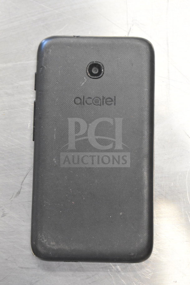 Black Alcatel smartphone with rear camera; textured back cover; minor scuffs visible.