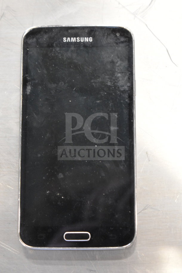 Samsung smartphone, black screen, slight wear. Part of auction lot including Samsung laptop and three other smartphones.