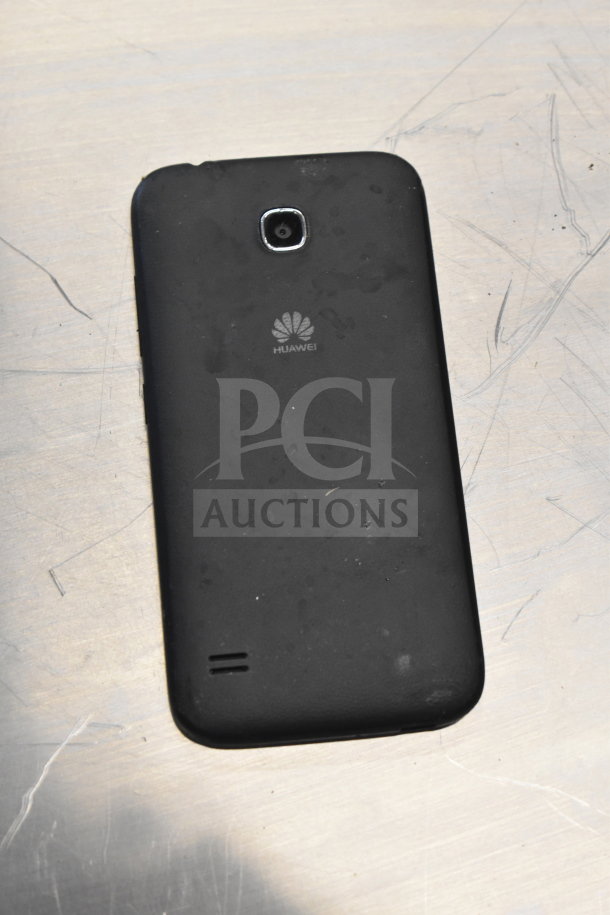 Black Huawei smartphone with rear camera, used condition, visible Huawei logo. Included in a lot with Samsung laptop and other phones.