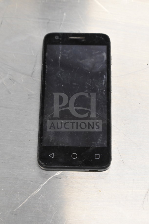 Worn black smartphone with visible scratches on the screen, features home and navigation buttons at the bottom.