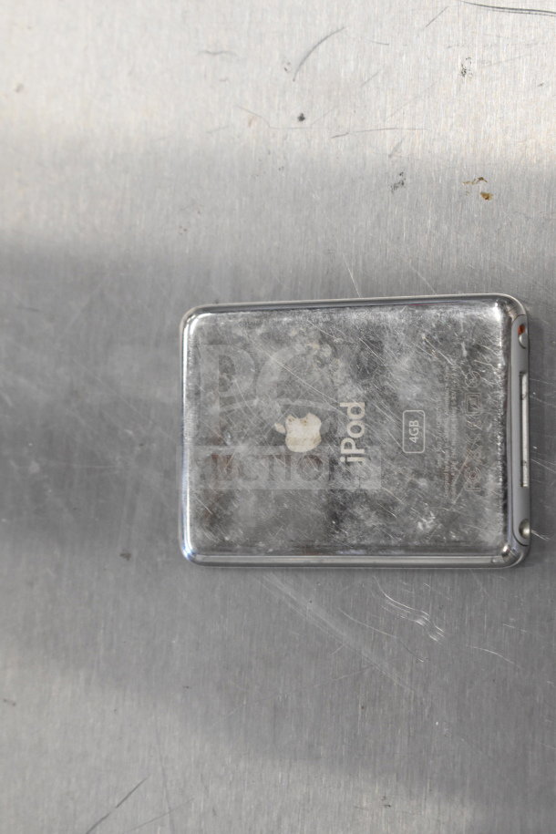 Scratched silver iPod with Apple logo and "iPod 4GB" marking on metal surface. Used condition.