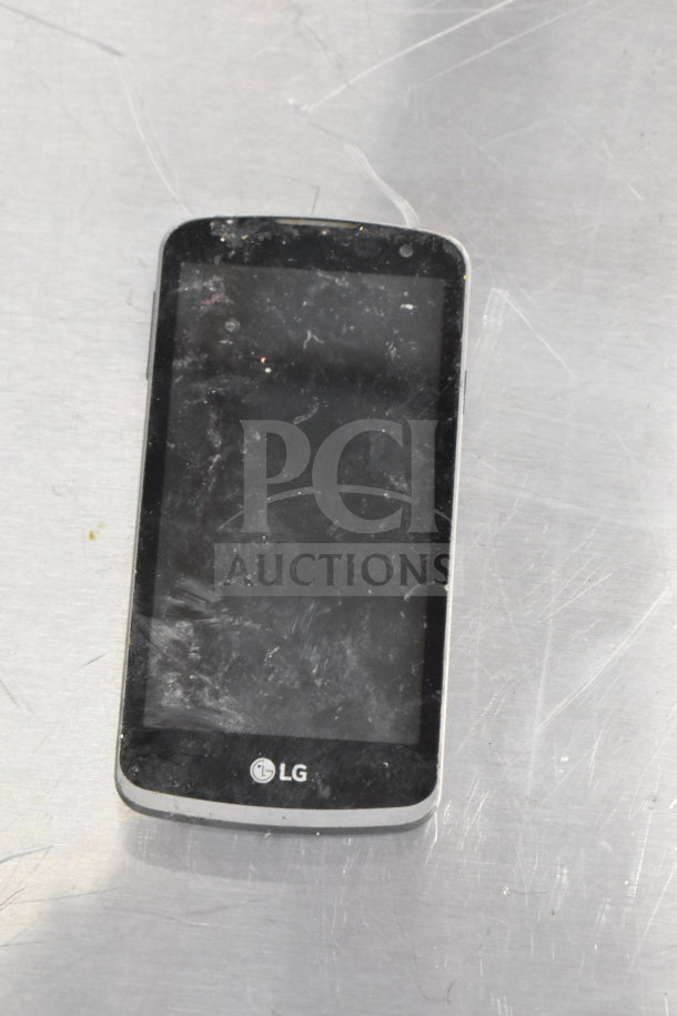 LG smartphone with visible wear on screen, part of an 8-item auction including iPods and other smartphones.