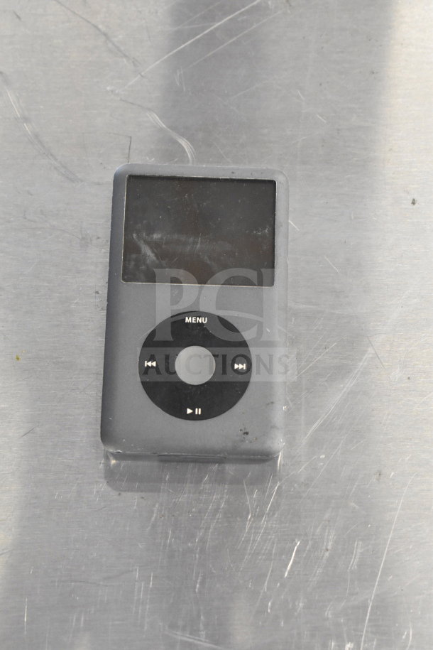 Gray iPod with black click wheel, showing some wear. Potentially part of a lot including various electronics like smartphones.