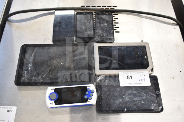 Seven electronic items including Genesis Ultimate Portable Game Player and three smartphones, showing signs of wear. Auction ID 51.