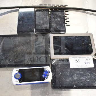 Seven electronic items including Genesis Ultimate Portable Game Player and three smartphones, showing signs of wear. Auction ID 51.
