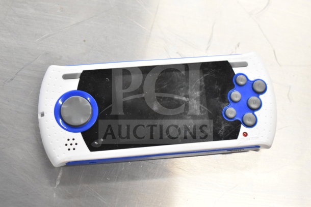 Genesis Ultimate Portable Game Player, white and blue, slightly worn, with visible buttons and screen, low battery indicator.