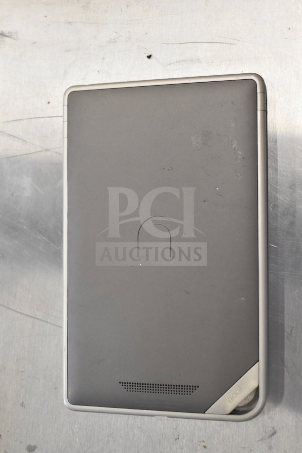Barnes & Noble Nook e-reader, gray, lightly scratched, showing back with "nook" text in corner, ventilated speaker.