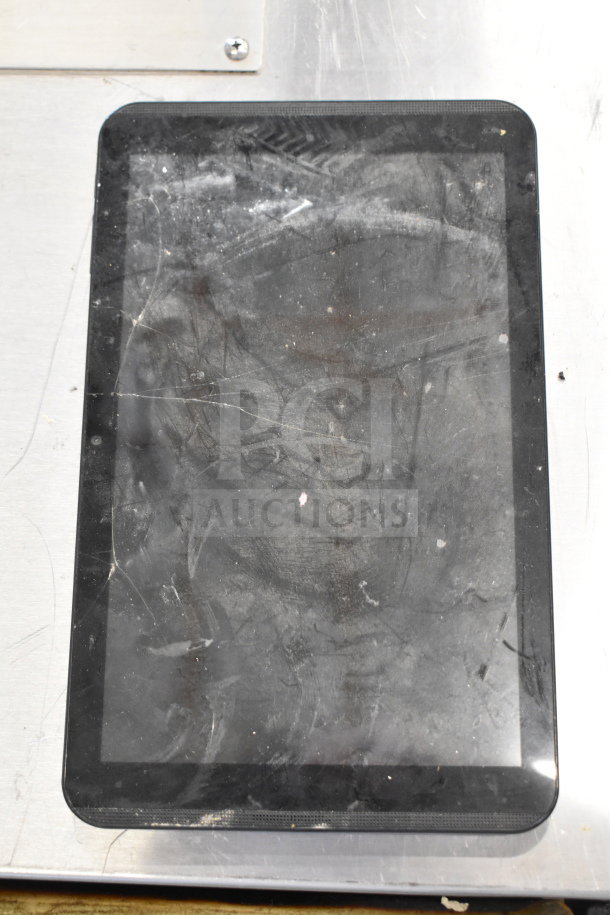 Worn tablet with dirty screen, part of a mixed auction lot including Genesis Ultimate Portable Game Player and smartphones.