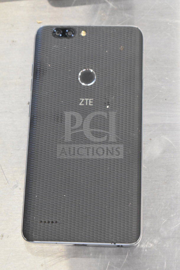 ZTE smartphone with dual cameras and fingerprint scanner. Textured back cover, visible wear marks.
