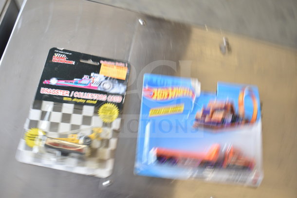 Blurred image of packaged Hot Wheels and Racing Champions die-cast cars on display.
