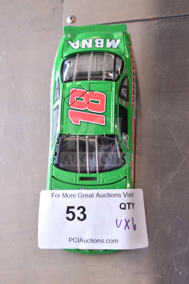 Green die-cast car model with number 18, labeled "MBA." Auction tag shows lot number 53, QTY 6.