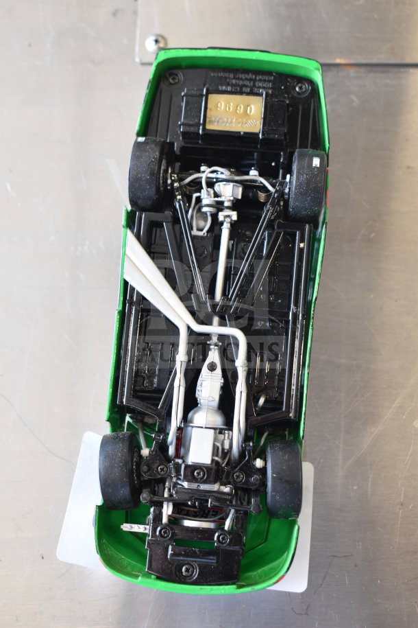 Underneath view of a die-cast car with detailed chassis, visible serial number 9690, part of a multi-item auction lot.