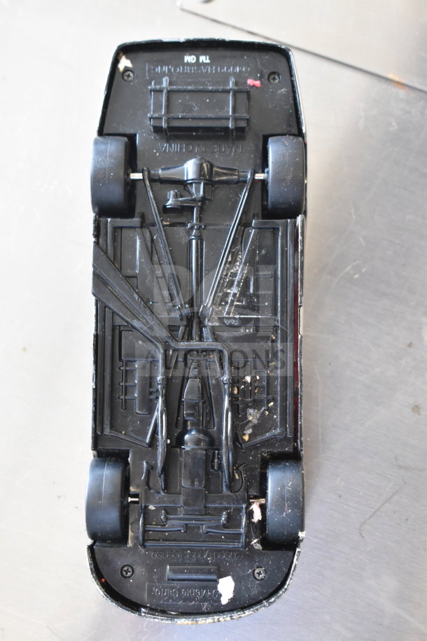 Underside view of a die-cast car model showing detailed chassis, "Made in China" marking visible.