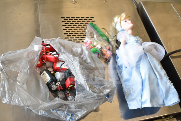 15-item lot: Cinderella doll, Tamagotchi, Strawberry Shortcake figurines, dinosaur toy, hand sanitizer cozies.
