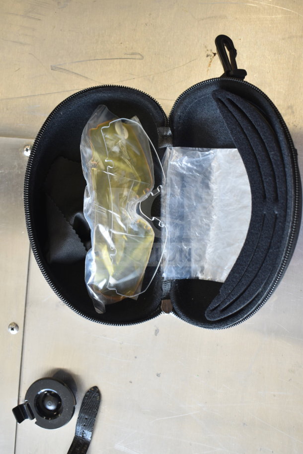 Case with sunglasses partially wrapped, watch strap, and additional accessories, suggesting mixed items auction lot.