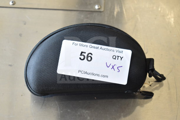 Black zippered case with auction label reading "56 QTY Vx5, PCIAuctions.com." Contains sunglasses, watches, fitness watch.