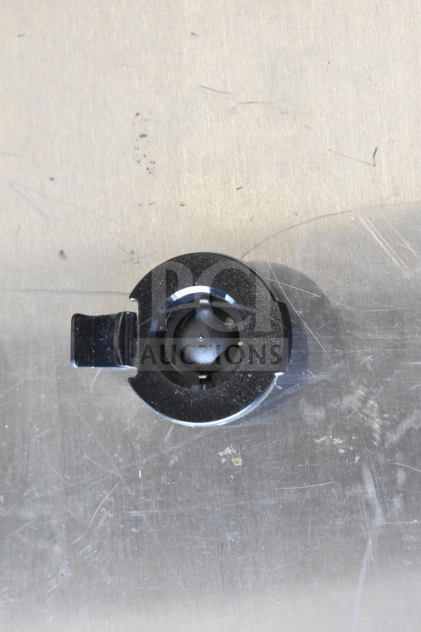 Alt text: Black plastic component on a metallic surface. Specific details unavailable for the auction item set.
