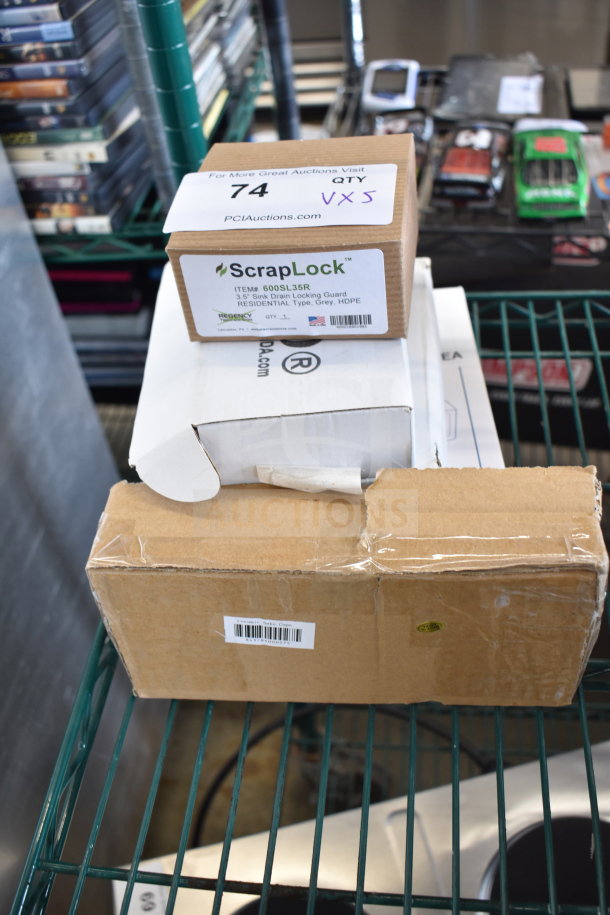 5 brand new items including ScrapLock 600SL35R locking drain strainer, Conair WCR14 alarm clock radio, ceramic sake cups. Boxes on shelf.