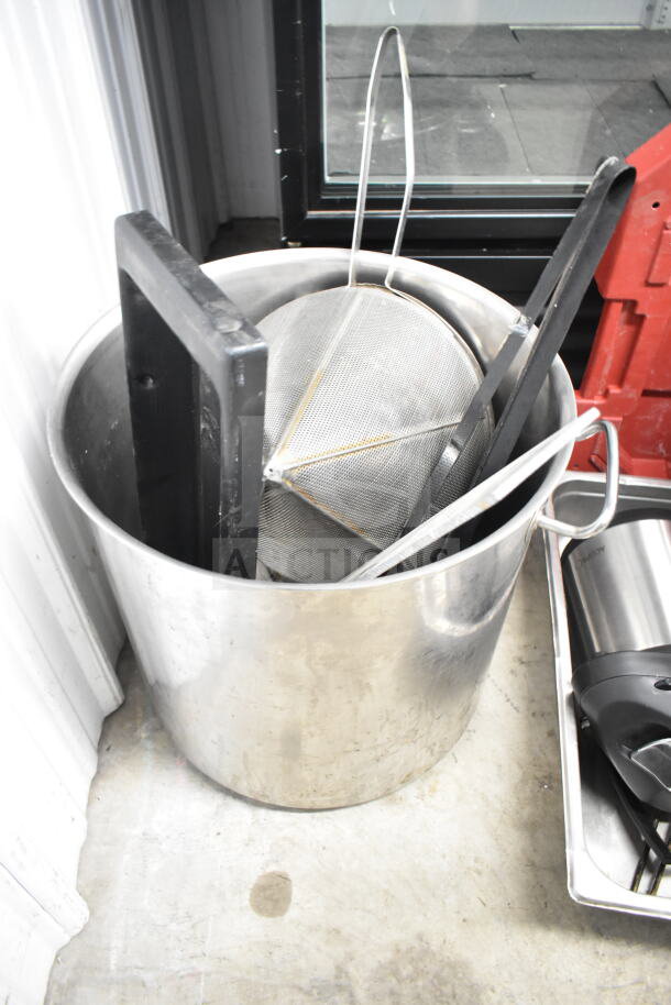 Stainless steel stock pot containing a china cap strainer, black cutting boards, and an air pot. Good condition.
