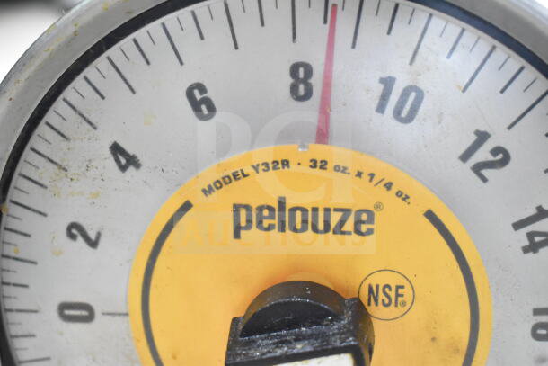 Close-up of a Pelouze Model Y32R scale face, marked NSF, 32 oz. x 1/4 oz., with visible wear around the dial.