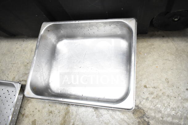Stainless steel culinary pan, used, with minor wear visible on interior surface. Part of varied kitchen equipment lot.