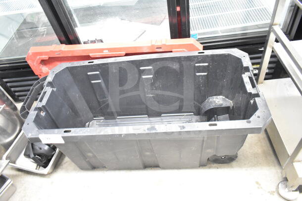 Large black plastic bin containing a colander, stock pot, China cap strainer, air pot, and scale, all in used condition.