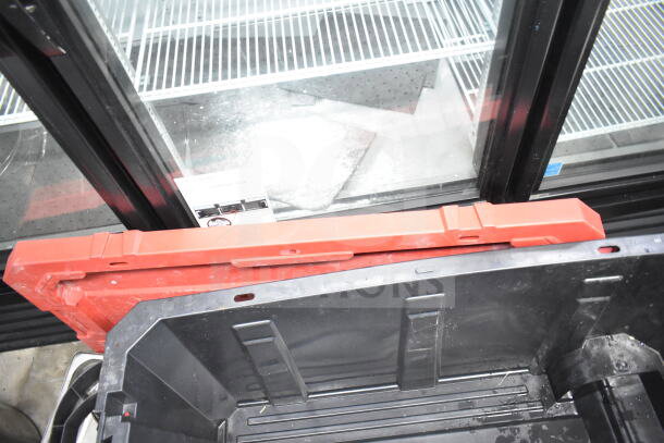 A lot of kitchen items including a black plastic bin, red container lid, and shelving in a commercial setting.