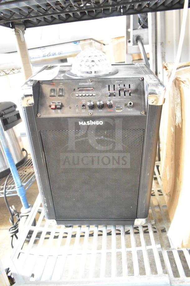 Masingo Soprano X1 Karaoke Machine, black, featuring control panel, LED indicators, and disco light on top. Good condition.