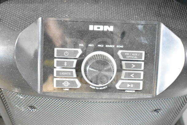Ion MK2 Party Rocker Max Karaoke Machine control panel with knobs and buttons for volume, mic, source, and echo functions.