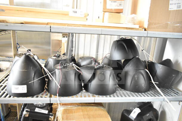 11 Crestron Saros PD6T-B-T-EACH speakers on metal shelves, wiring visible, light wear. Auction lot tags in view.