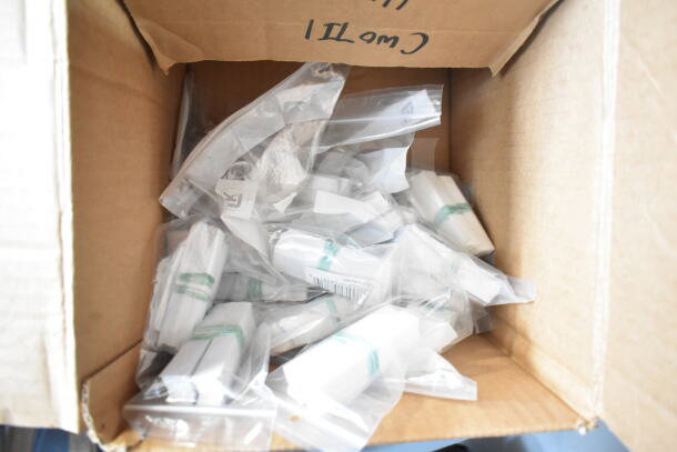 Box containing a lot of brand-new scratch and dent deli tags, including 512XKD105 and 512XKD710BK models in sealed bags.