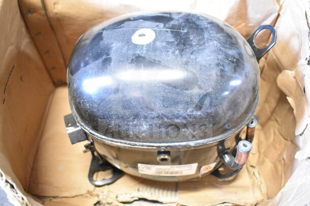 Embraco NT6222UV Compressor in box, 115 Volts, 1 Phase, shows moderate wear, visible label with specifications.