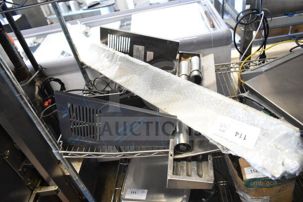 A collection of nine items including metal panels and legs, wrapped in protective material, displayed on metal shelving.