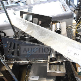 A collection of nine items including metal panels and legs, wrapped in protective material, displayed on metal shelving.