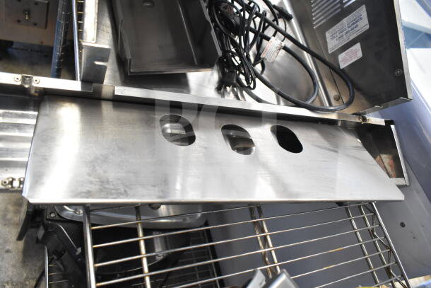 Nine assorted metal items including panels and legs, featuring power cords and a label with contact info. Items in used condition.