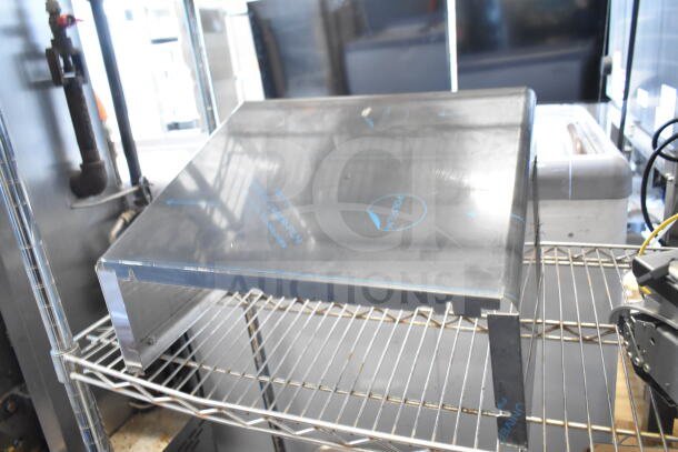 Alt text: Metal panel on wire shelf; includes branding and protective film markings. Part of auction lot with 9 varied items.