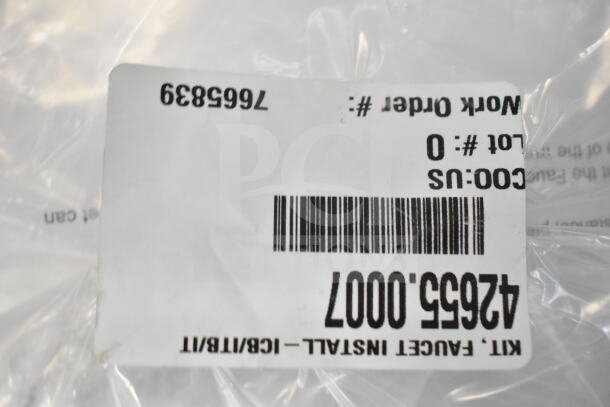 Plastic-wrapped package with barcode and label showing "42655.0007 Faucet Kit." Part of a mixed auction lot.