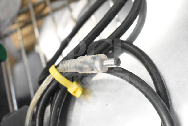 Close-up of a metal connector attached to a black cable with a yellow tag, part of a 42655.0007 Faucet Kit.