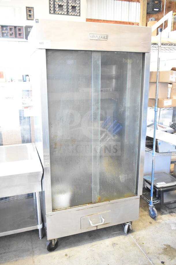Attias commercial natural gas rotisserie oven, 70,000 BTU, on casters. Stainless steel with visible wear. Model details on label.