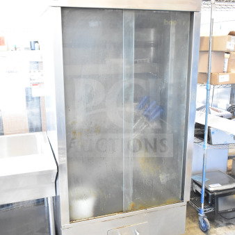Attias commercial natural gas rotisserie oven, 70,000 BTU, on casters. Stainless steel with visible wear. Model details on label.