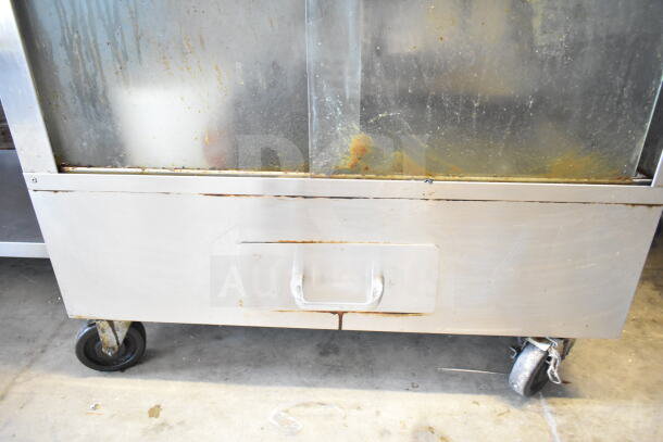 Attias commercial rotisserie oven, natural gas powered, 70,000 BTU, on commercial casters, visible wear and rust.